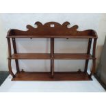 A mahogany hanging wall shelf, brass line inlaid, with fret carved surmount. 35' wide