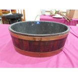 An oak and copper coopered oval jardiniere. 16' wide