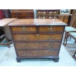 A George III mahogany and burrwood (probably yew) chest of two short over three long drawers on ogee