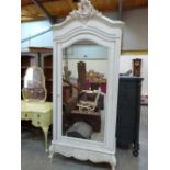A 19th century French painted pine armoire with shell and foliate carved pediment over a mirror door