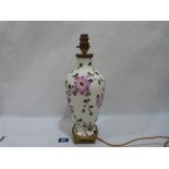 A ceramic lamp base painted with flowers on ormolu base. 12½' high