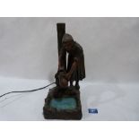 An early 20th century cold painted metal figure of a woman collecting water, the glass pool