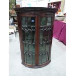 A George III mahogany bowfronted hanging corner cupboard. 47' high