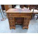 A yew wood kneehole desk in 18th century style, the distressed leather inlet top over a long