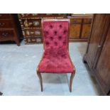 A Victorian walnut slipper chair upholstered in deep buttoned red velvet