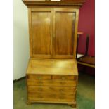 An 18th century walnut bureau bookcase, the upper part enclosed by a pair of panel doors, the base