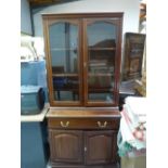 A Rhodesian mahogany bookcase enclosed by a pair of glazed doors over base with long drawer and