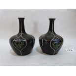 A pair of Mintons globular vases painted with bluebells in four jewelled reserves on a black ground.
