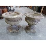 A pair of garden urns. 17' high. (One with loss to base)