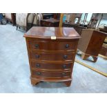 A yew veneered bedside chest of four drawers