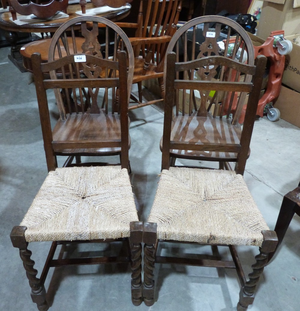 A pair of wheelback chairs and a pair of rush seated chairs