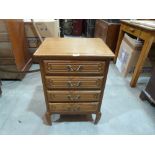 An oak bedside chest of four drawers