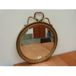 A 19th century gilt wood and gesso looking glass with circular bevelled plate. 18' diam.