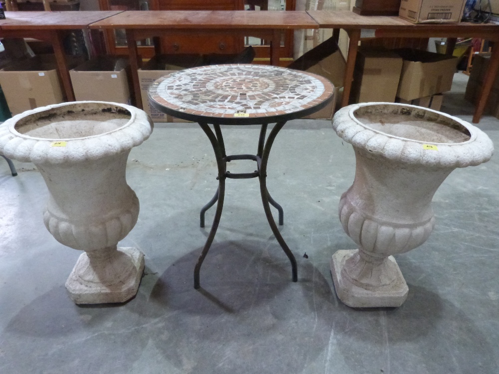 A metal patio table and a pair of plastic campana urns