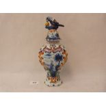 A 19th century faience inverted baluster vase, the domed cover with parrot finial. 11' high