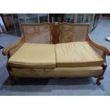 A 1920s walnut bergere sofa. 55' wide