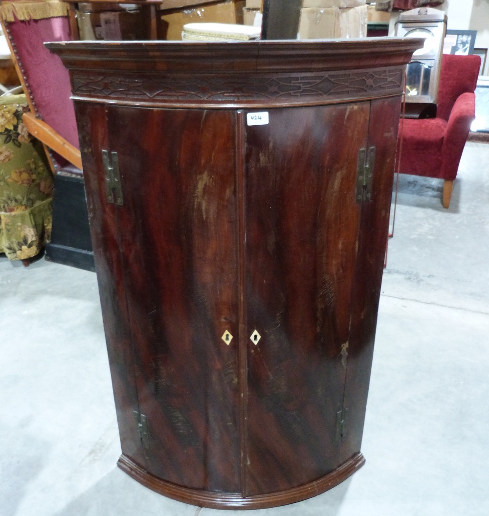 A George III mahogany bowfronted hanging corner cupboard. 44' high