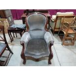 A Victorian mahogany spoonback parlour armchair raised on cabriole volute carved legs