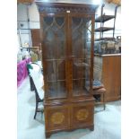 A George III style mahogany and inlaid bookcase, enclosed by a pair of astragal glazed doors over