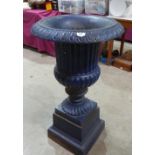 An early 20th century cast iron campana garden urn on stepped square socle base. 39' high