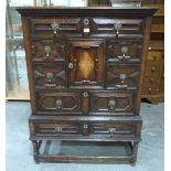 A 17th century style joined oak chest-on-stand with inlaid cupboard door and an arrangement of seven