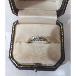 A three stone diamond ring. In gold marked 18. Size O½. 2g gross