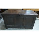 An 18th century joined oak chest, the three panel fielded front over a wavy apron, raised on stiles.