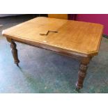 A late Victorian oak dining table extending to 70' with one extra leaf
