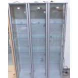 Three narrow glazed display cabinets