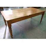 A Victorian pine kitchen table, the plank top over an end frieze drawer, on turned legs. 77' long
