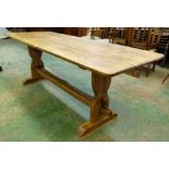 An oak refectory table, the plank top raised on hourglass shaped trestle supports. 84' long
