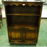 An oak bookcase with two shelves over a cupboard enclosed by two doors. 36' wide. Worm to feet and