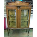 An Edward VII mahogany and inlaid serpentine china display cabinet enclosed by a pair of leaded