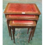 A nest of three mahogany occasional tables with leather inlet tops