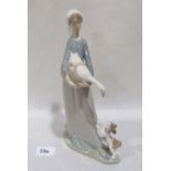 A Lladro figure of a goose girl with dog. 10¾' high