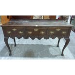 A 19th century joined oak low dresser with three drawers and shaped apron, on cabriole legs. 61'