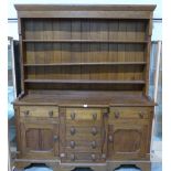 An oak breakfront dresser with raised rack