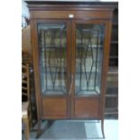 An Edward VII mahogany and inlaid display cabinet enclosed by a pair of astragal glazed doors. 34'