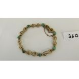 A green stone open link bracelet. In gold marked 9ct. 8g gross