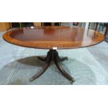 A 19th century mahogany oval snaptop breakfast table on leaf molded quadripartite support. 59' wide