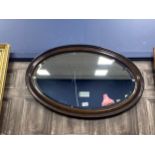 A MAHOGANY FRAMED OVAL WALL MIRROR