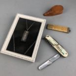 A FRAMED SILVER INGOT PENDANT ON CHAIN, TWO PENKNIVES AND OTHER ITEMS
