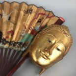 A LOT OF FOUR CHINESE PAINTED FANS AND A GILT BUDDHA WALL MASK