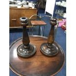 A PAIR OF TURNED WOOD CANDLESTICKS ALONG WITH A BAKELITE SEWING BOX, BOBBINS AND OTHER VINTAGE ITEMS