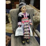 A 20TH CENTURY PLASTIC DOLL IN TRADITIONAL HMONG DRESS