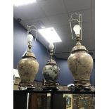 A PAIR OF FLORAL AND GILT TABLE LAMPS AND ANOTHER LAMP