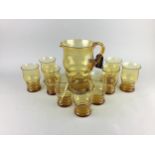 AN AMBER GLASS LEMONADE SET ALONG WITH CHAMPAGNE COUPES AND OTHER CERAMICS