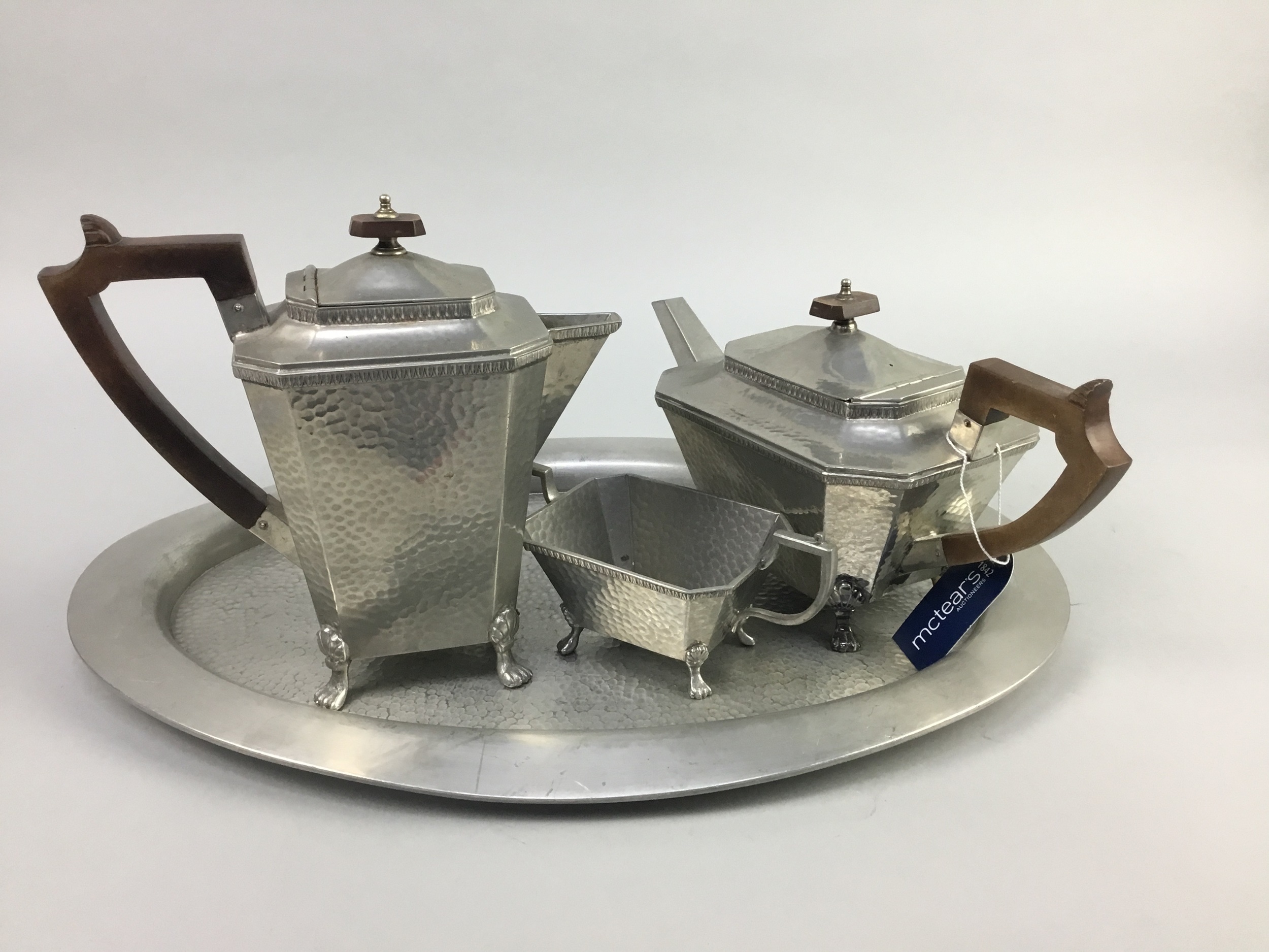 AN EARLY 20TH CENTURY HAMMERED DON PEWTER FOUR PIECE TEA SERVICE