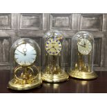 A KUNDO ANNIVERSARY CLOCK WITH GLASS DOME AND TWO OTHERS