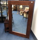 A LARGE STAINED WOOD WALL MIRROR